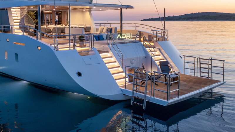 Luxury yacht at dusk showcasing illuminated stairways and spacious decks