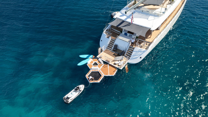 Aerial view of a spacious sailing yacht anchored in the serene blue waters